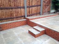 walls, steps and split patio with feather edge fencing and recessed posts.