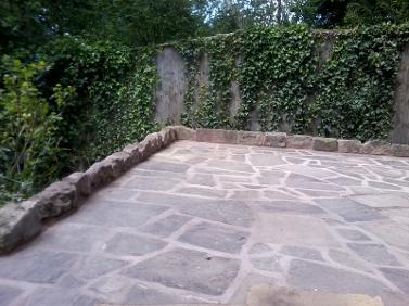 raised patio with sandstone wall.