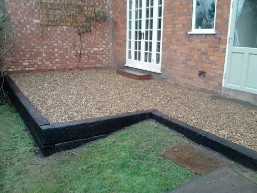Railway sleeper walls and gravel patio built in rear garden.