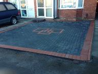 Inlaid pattern in block paved driveway.