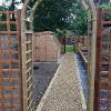 Back archway and gravel pathway with potting shed.